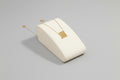 A gold necklace with a geometric pendant displayed on a white surface.