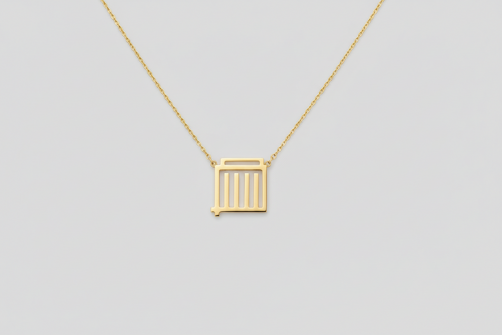 Gold necklace with a square pendant worn by a person against a neutral background